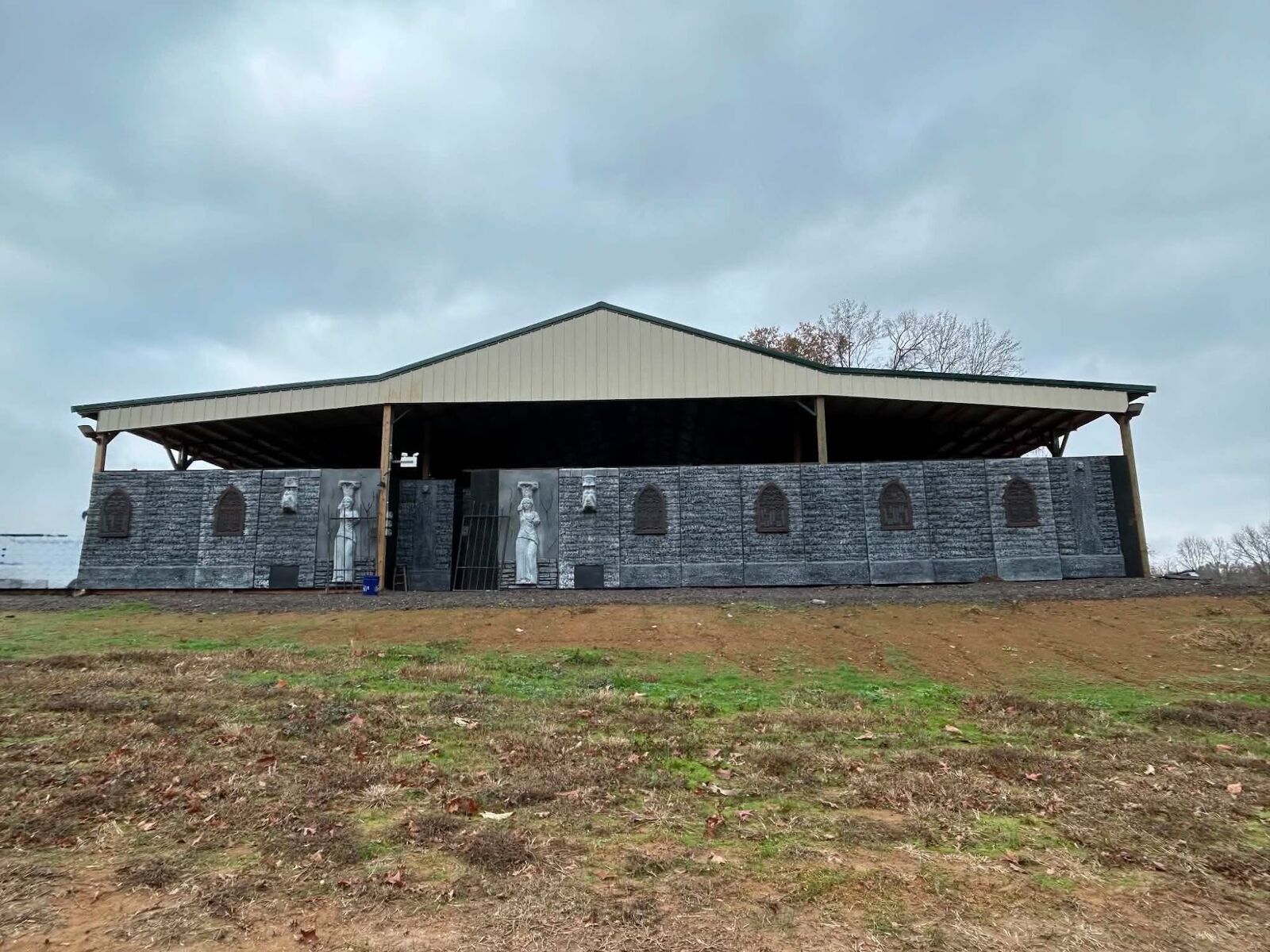 A large open-sided barn building with a metal roof