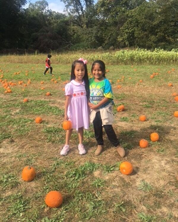 Two girls standing in the pumpkin patch