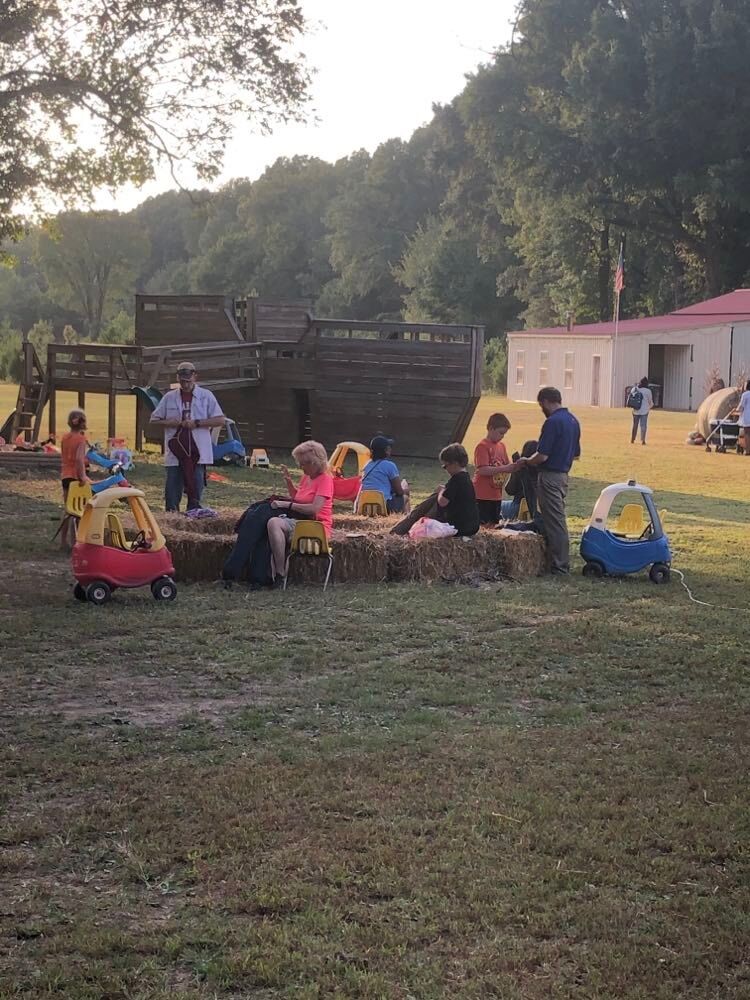 Kids and families in the playground area by the wooden ship