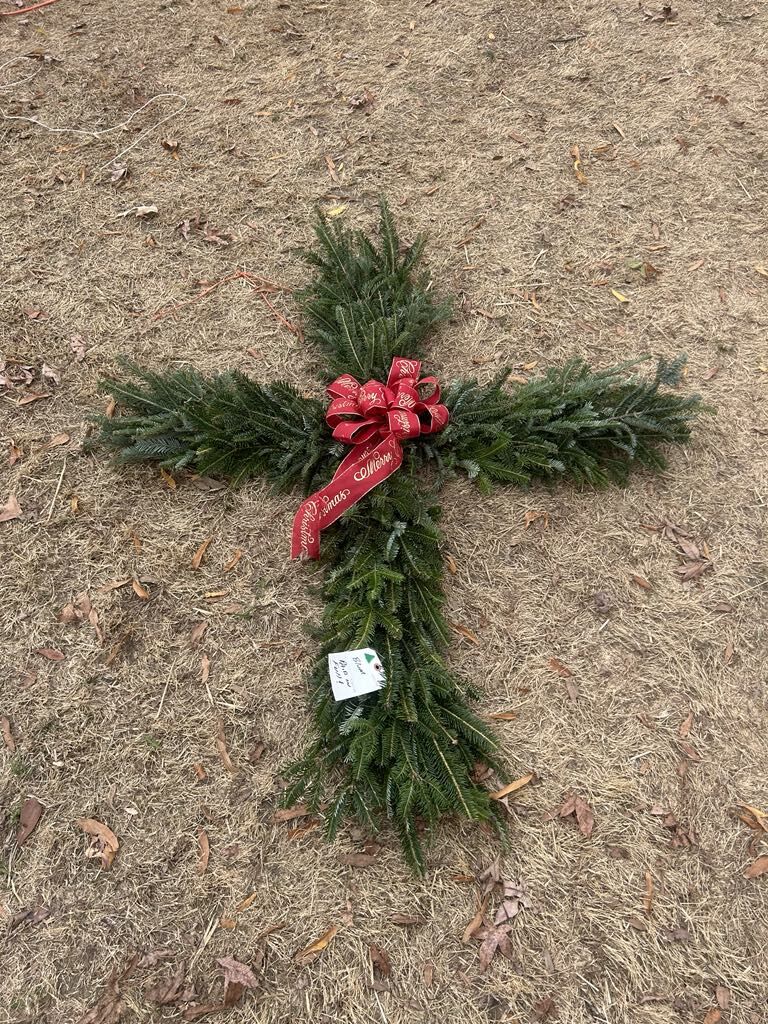 An evergreen cross with a red bow